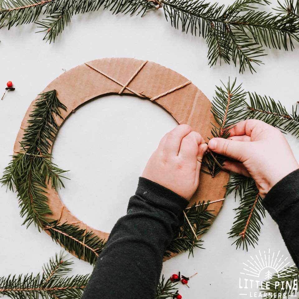 Try making this simple and adorable Christmas wreath for kids with real pine branches and cardboard!