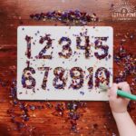 Try using these hands-on alphabet and number tracing boards with your favorite nature sensory bin filler for a fun way to learn how to write numbers and letters! Children will love tracing the numbers and letters and sweeping the flower confetti pieces into the tracing board with a paint brush.